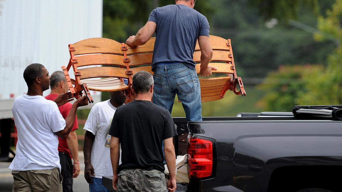 A customer is helped loading a group of three old wooden seats from Bojangles Coliseum to his truck on Wednesday, September 9, 2015. The few hundred people lucky enough to get Bojangles seats during an online sign up earlier this year arrived to pick them up on Wednesday.