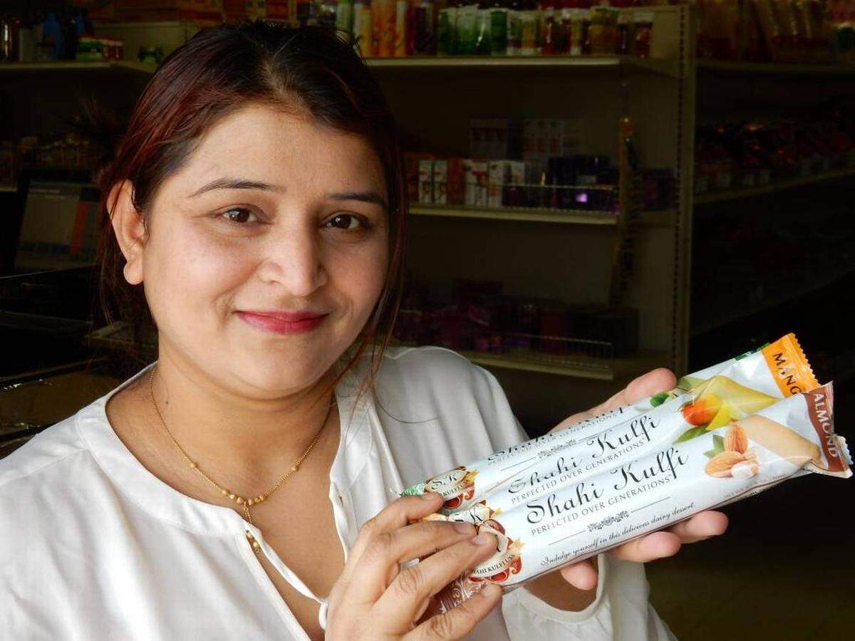 Meena Chamlagai shows off South Asian style ice cream bars, $1.99 each at Rohan Grocery.