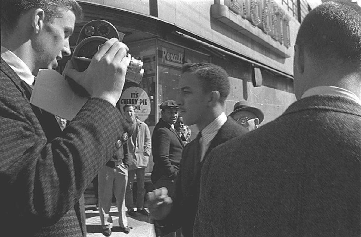 Charles Jones, talking to reporters in February 1960, answers questions about the intentions of student protesters.