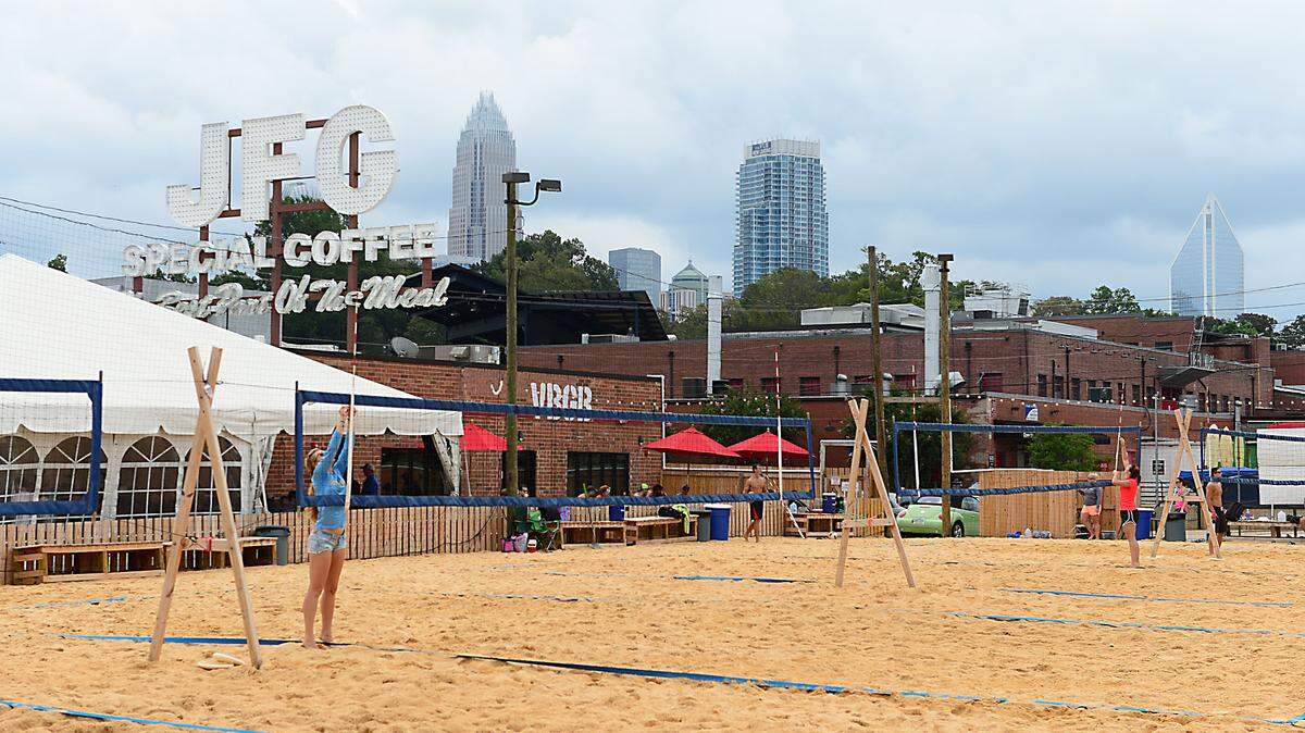 Volleyball nets are prepared for players outside the VBGB Beer Hall at the NC Music Factory in uptown Charlotte Saturday, Sept. 12, 2015. Three teens have been arrested following a late-night shooting that injured five at the popular venue.