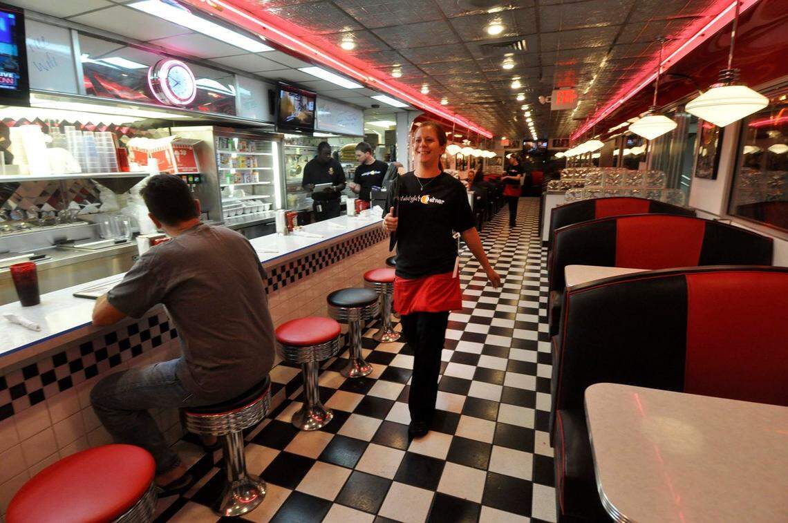 Midnight Diner waitress Bonnie Owens takes menus to customers. The diner is open 24/7.