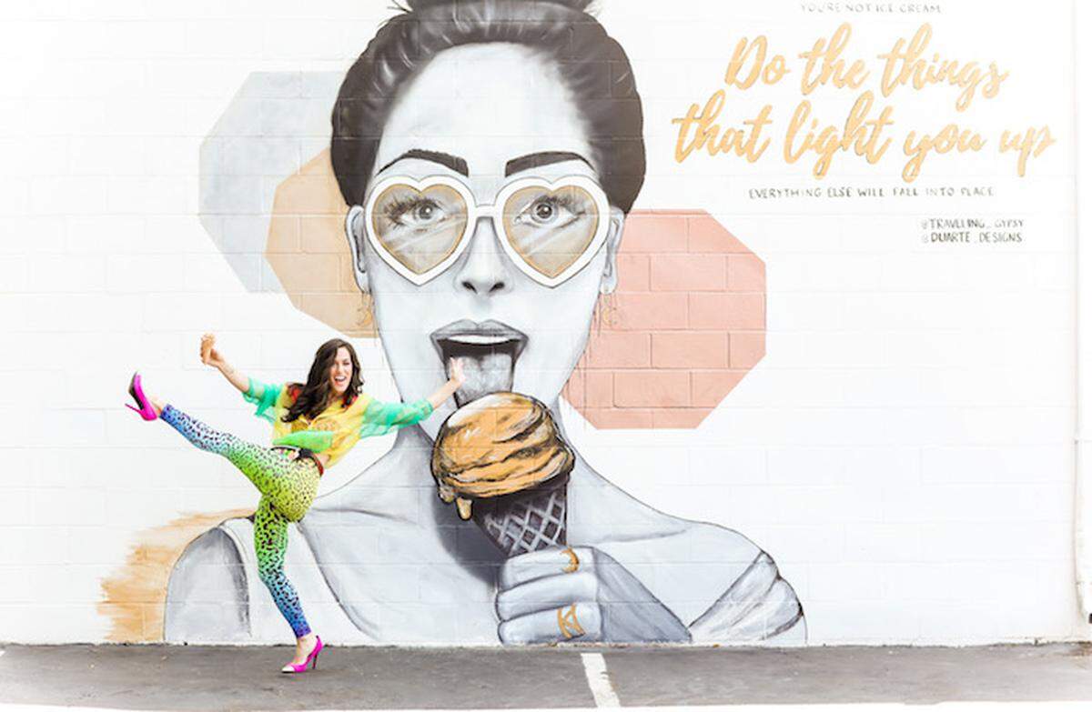 Sydney Duarte poses with her mural outside Two Scoops.