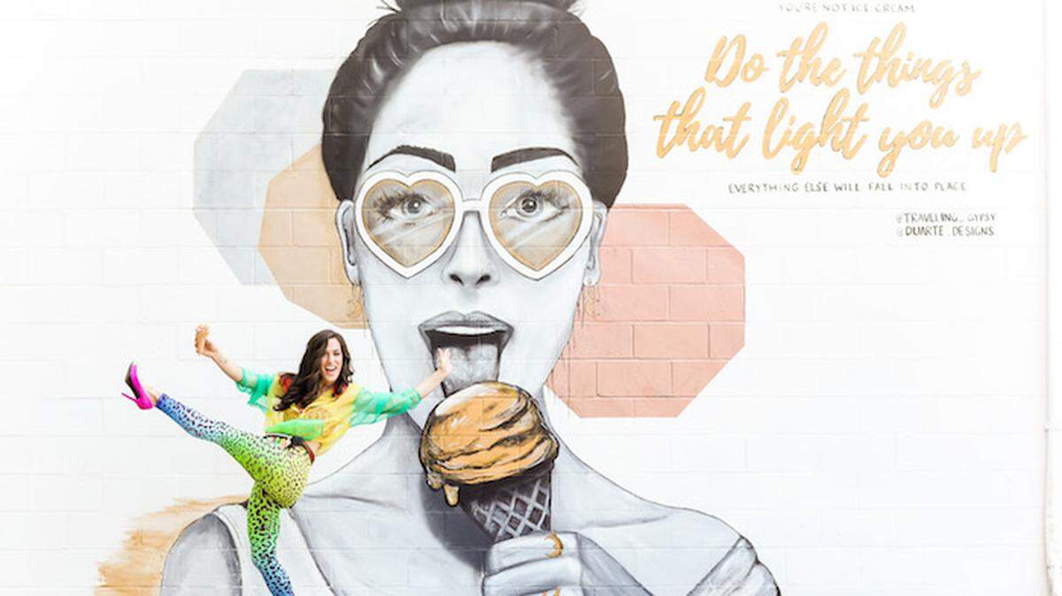 Photo by Ariel Perry<br>Sydney Duarte poses with her mural outside Two Scoops.