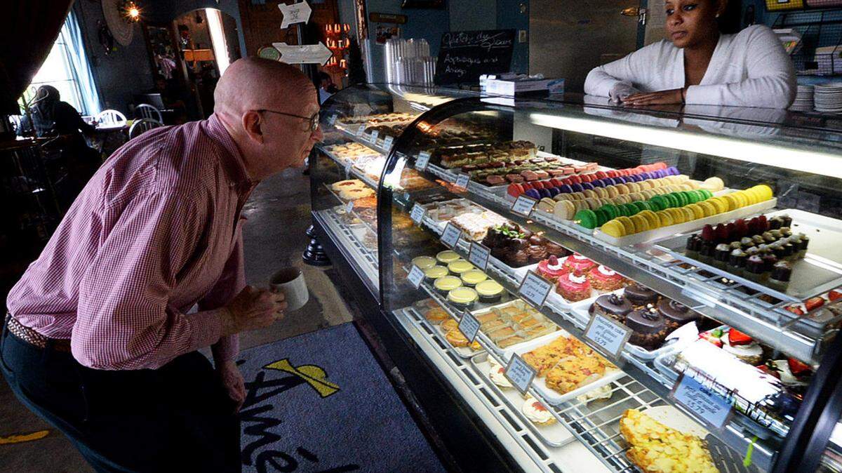 CharlotteFive archives<br/>Customer Ron Touchstone looks over the bakery products as employee Dominique Stance looks on at right at the original Amelie's location in Villa Heights in 2015.