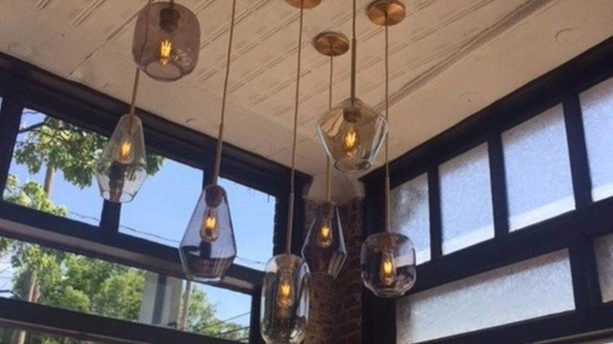 Inside, The Stanley has a mix of old, like the restored glass storefront and tin ceiling, with contemporary touches, including pendant lights and the burgundy, gray and yellow color scheme. The restaurant closed for two days after an employee may have been exposed to the COVID-19 delta variant.