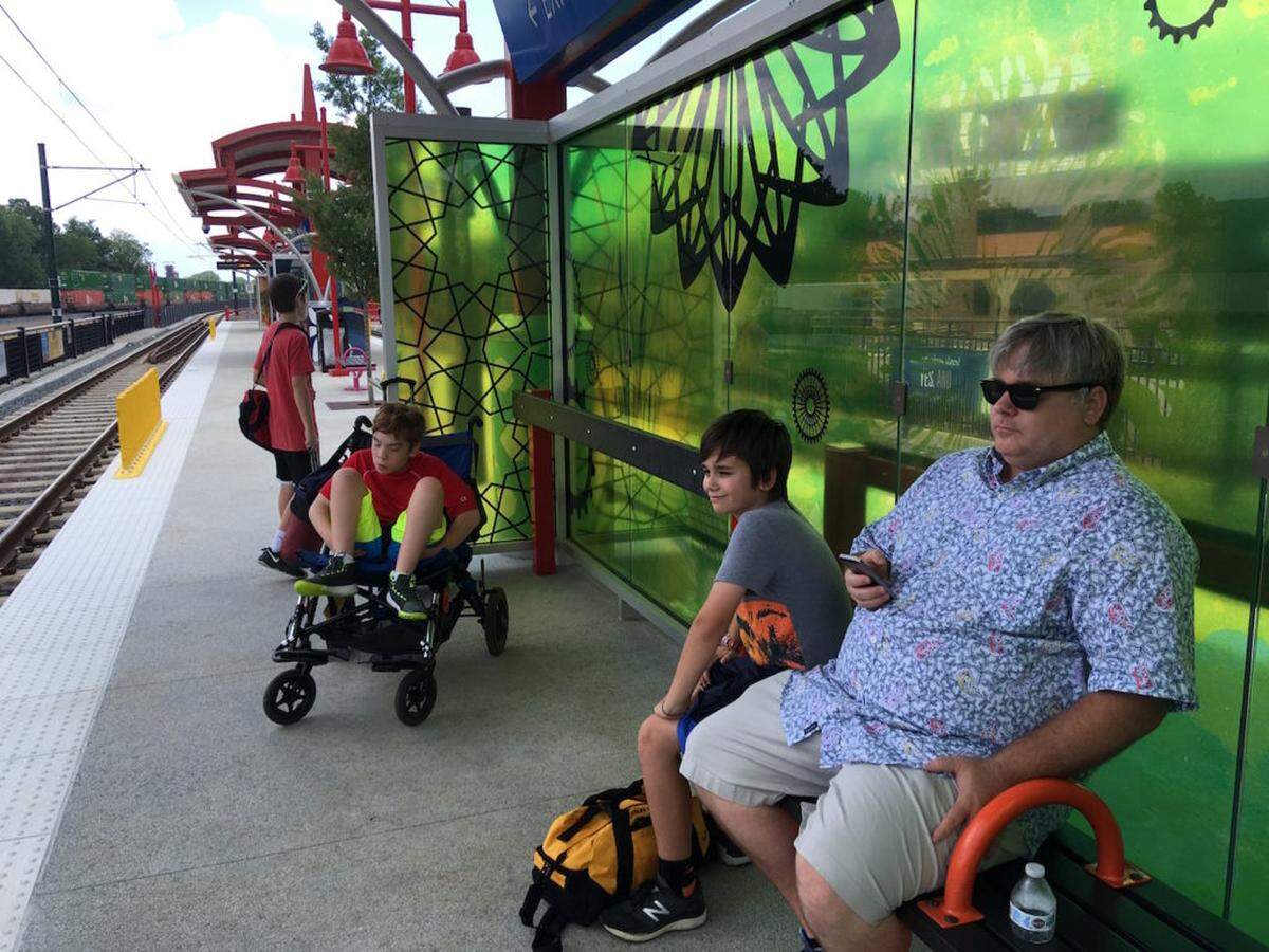 Photo by Vanessa Infanzon<br>The McCall family, waiting for the light rail in July 2019.
