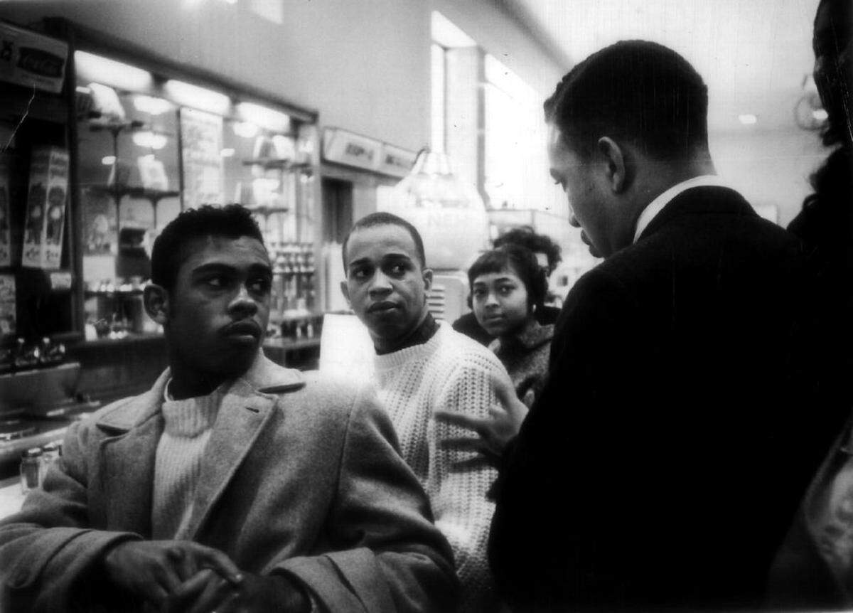 JCSU students demanding service at the Woolworth lunch counter in Charlotte on February 9, 1960 listen listen to protest leader Charles Jones (right), caution them to remain calm and peaceful. 1960 CHARLOTTE OBSERVER FILE PHOTO