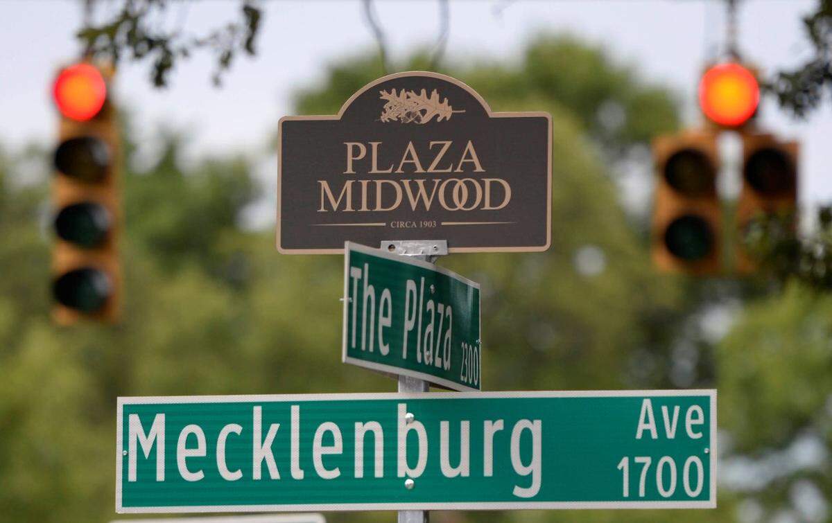 A Plaza Midwood neighborhood marker tops a street sign along The Plaza on Tuesday, July 14, 2015.