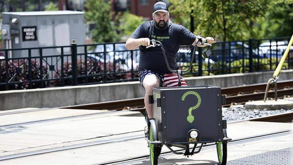 Brad Shell crossed the light rail line on Remount Road during a “no pants ride” through uptown Charlotte — one of many adventures he’s had as owner and head brewer of The Unknown Brewing Co.