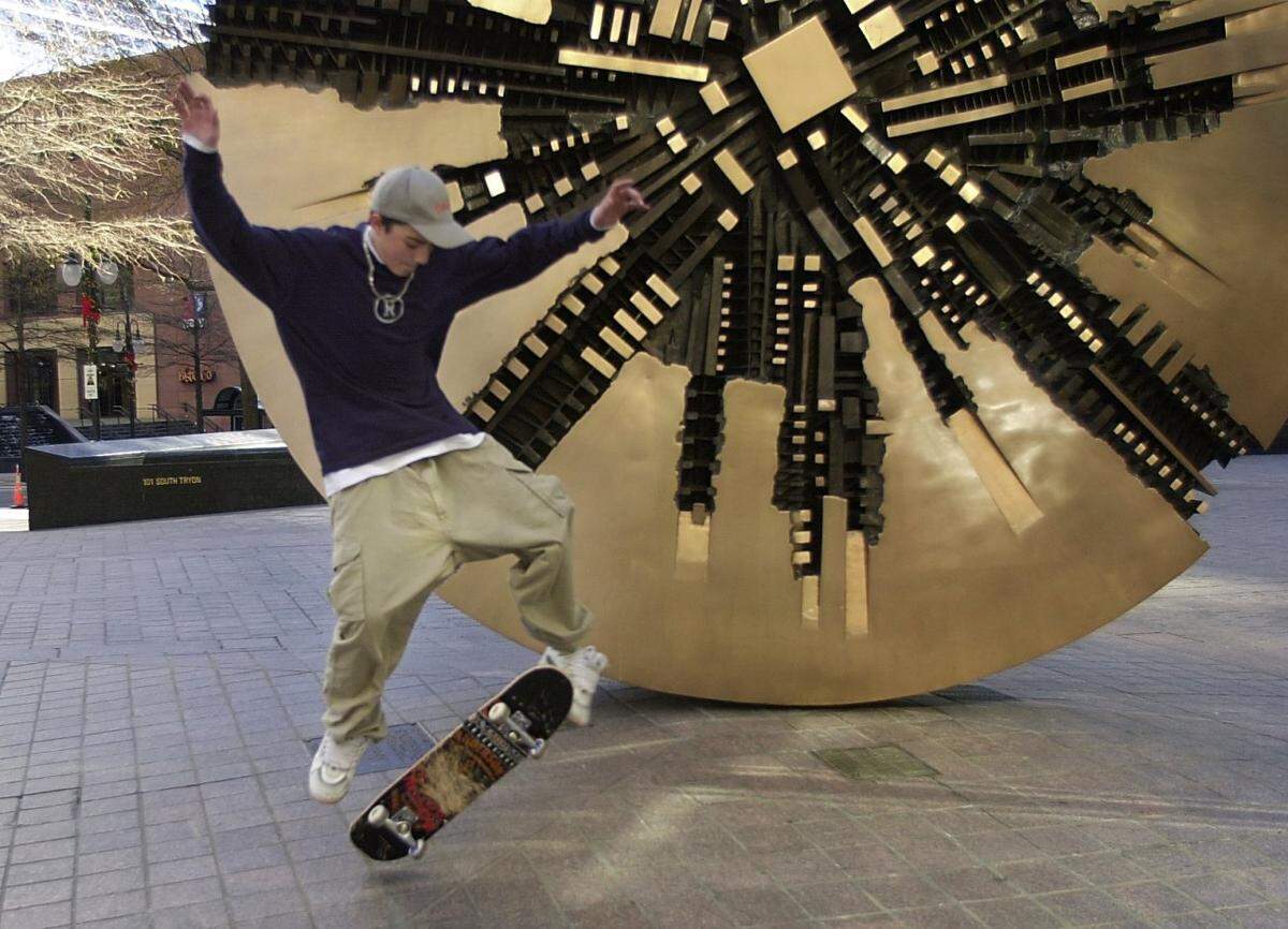 01/06/01  Mike Kaloudis (cq) and friends take advantage of the mild temperature Saturday in downtown Charlotte and skateboard around the sculpture "Il Grande Disco" at the corner of Tryon and Trade Streets.  Lou Ellen Plummer