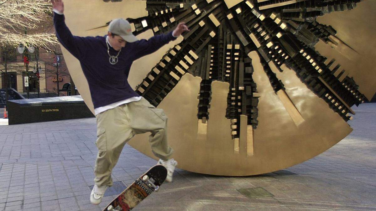 01/06/01  Mike Kaloudis (cq) and friends take advantage of the mild temperature Saturday in downtown Charlotte and skateboard around the sculpture "Il Grande Disco" at the corner of Tryon and Trade Streets.  Lou Ellen Plummer