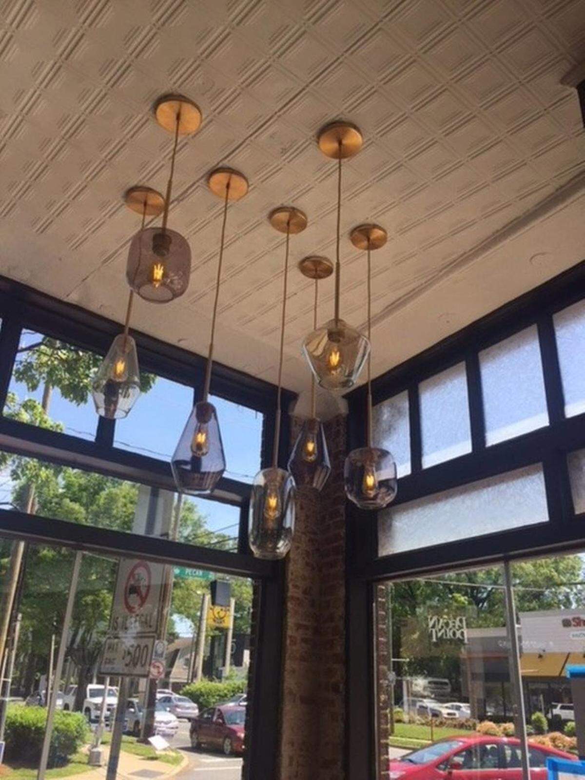 Inside, The Stanley has a mix of old, like the restored glass storefront and tin ceiling, with contemporary touches, including pendant lights and the burgundy, gray and yellow color scheme.Photo by Kathleen Purvis