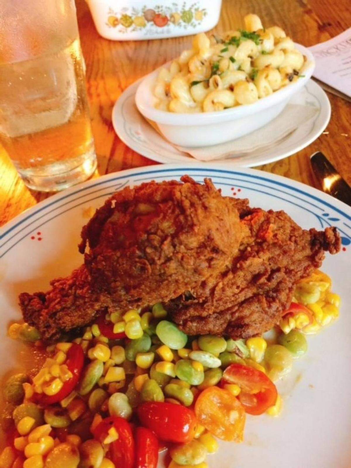 weet tea-brined fried chicken is served on a succotash with fresh tomatoes and a very creamy macaroni and cheese with shreds of collards. (Don’t worry, they’re not very collardy.)