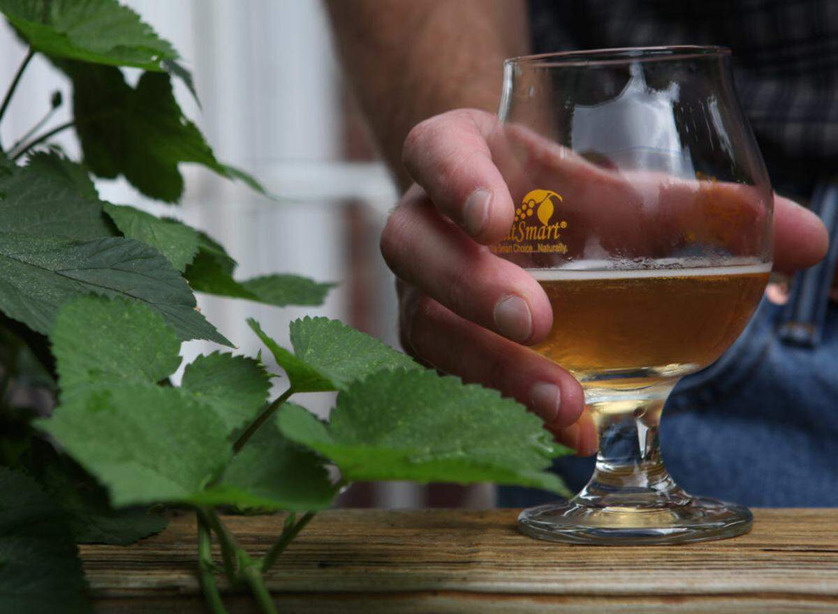 Homebrewer Brian Beauchemin, owner of GoodRoad CiderWorks, holds a glass of his hard cider on the porch of his South Charlotte home on Friday, May 30th 2014. Longtime homebrewer Brian Beauchemin created GoodRoad CiderWorks and is now looking for spaces in SouthEnd. Since there's not a location yet, he is brewing from his home and making small batches.