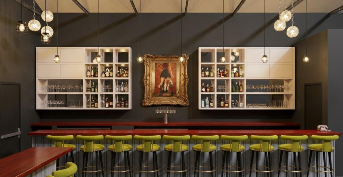 A dimly lit, modern bar featuring a long dark wood counter lined with chartreuse green velvet stools. Behind the bar, two white grid-style shelves flank a large, ornate gold-framed painting centered on a dark charcoal wall.