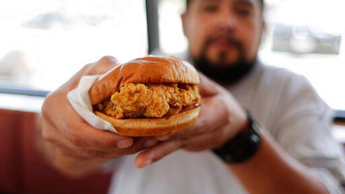 The Associated Press<br/>Randy Estrada holds up his chicken sandwiches at a Popeyes, Thursday, Aug. 22, 2019, in Kyle, Texas.