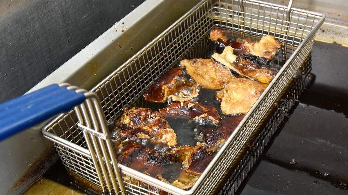 Photo by John D. Simmons/The Charlotte Observer<br/>After frying pork skins all week, Lewis Donald uses the pork-enriched oil to fry chicken on Sundays.