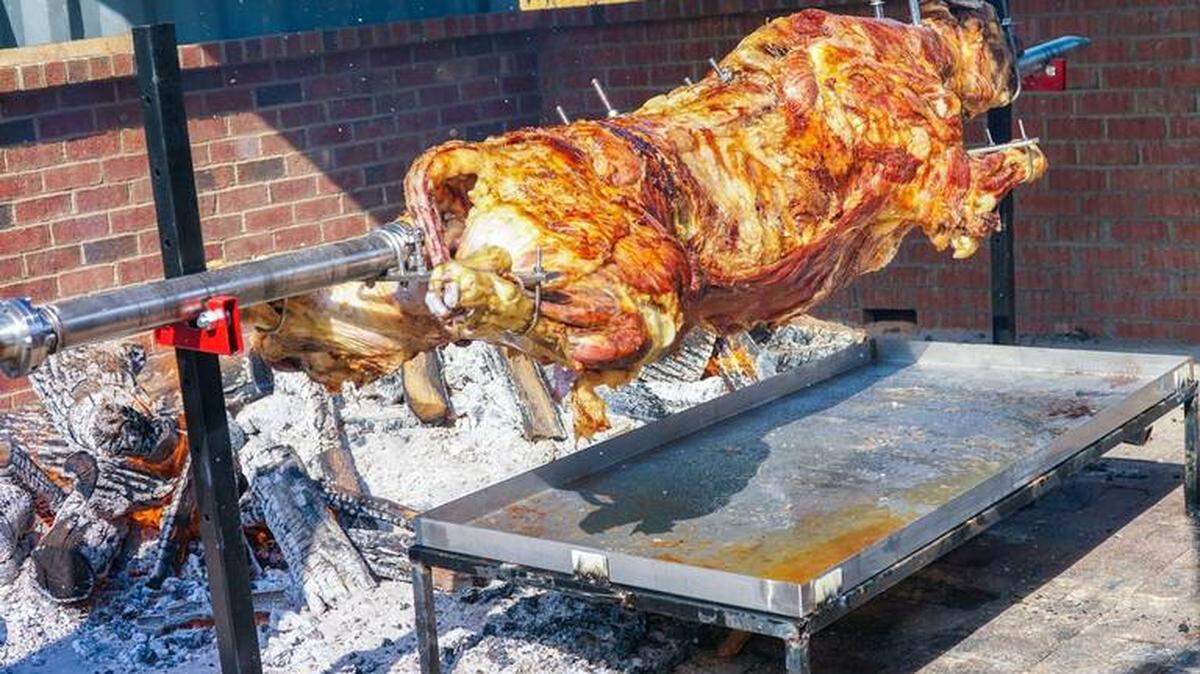Courtesy of Vlado Novakovic<br/>St. Simeon church members roast pigs and lambs on revolving skewers over an open fire.