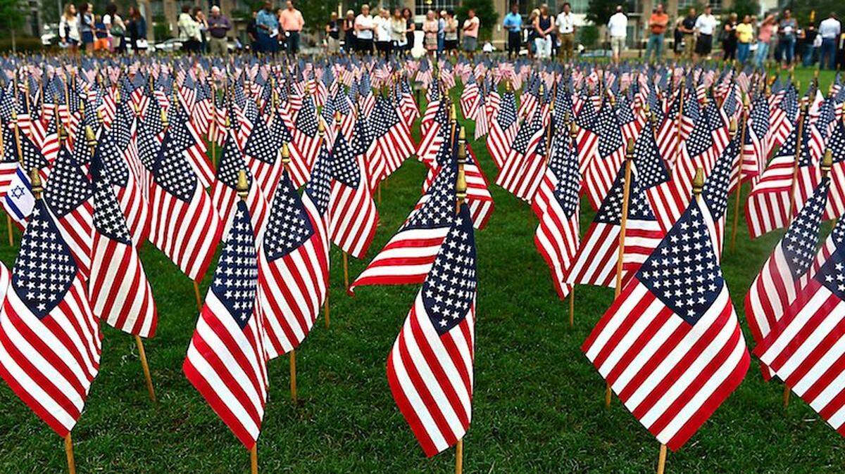 People gather for a memorial service at Romare Bearden Park in uptown Charlotte Friday, Sept. 11, 2015. 2,997 flags were placed in the park in the shape of the twin towers to honor the victims of the 9/11 terrorist attacks. Photo by Todd Sumlin, Charlotte Observer