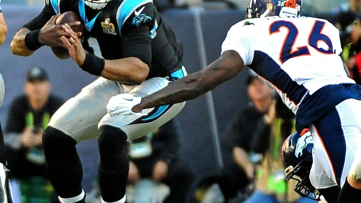 Carolina Panthers quarterback Cam Newton protects the ball as Denver Broncos safety Darian Stewart prepares to make the tackle during first quarter action at Levi's Stadium in Santa Clara, CA. on Sunday, February 7, 2016. The Denver Broncos defeated the Carolina Panthers 24-10.