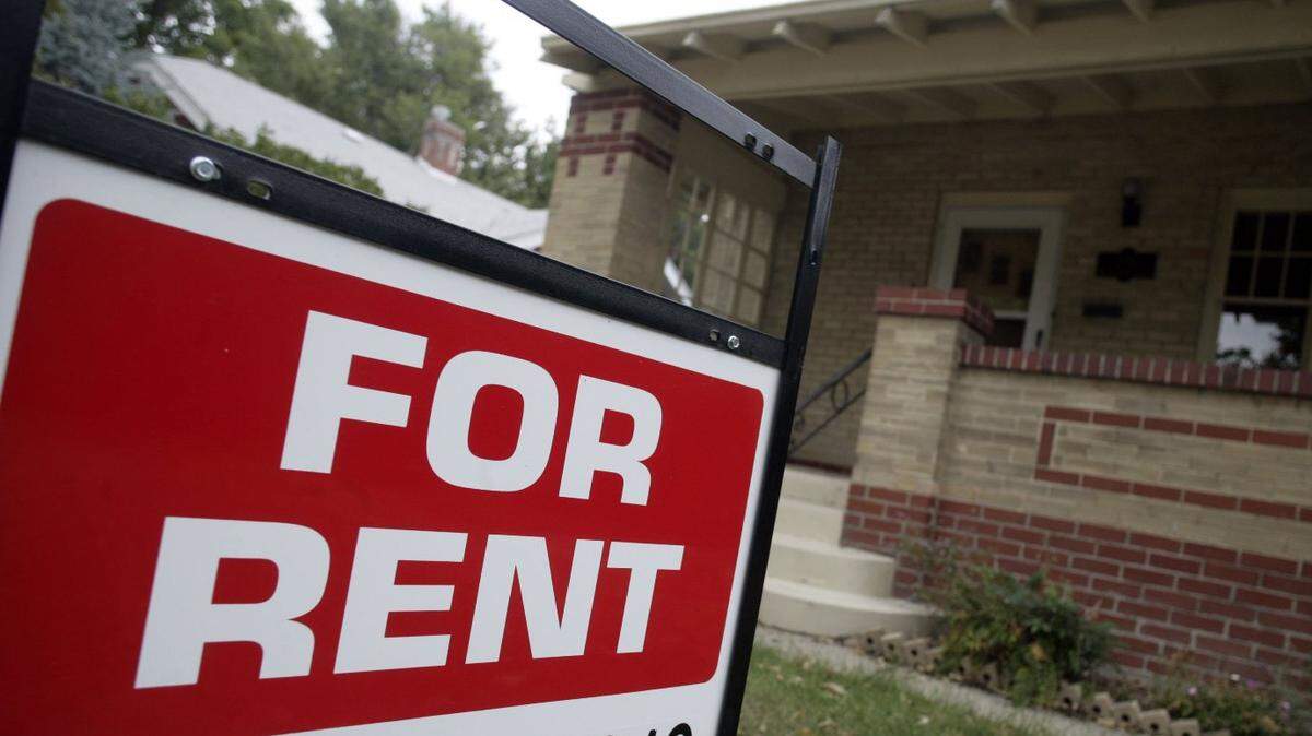 A “for rent” sign is posted outside a home.