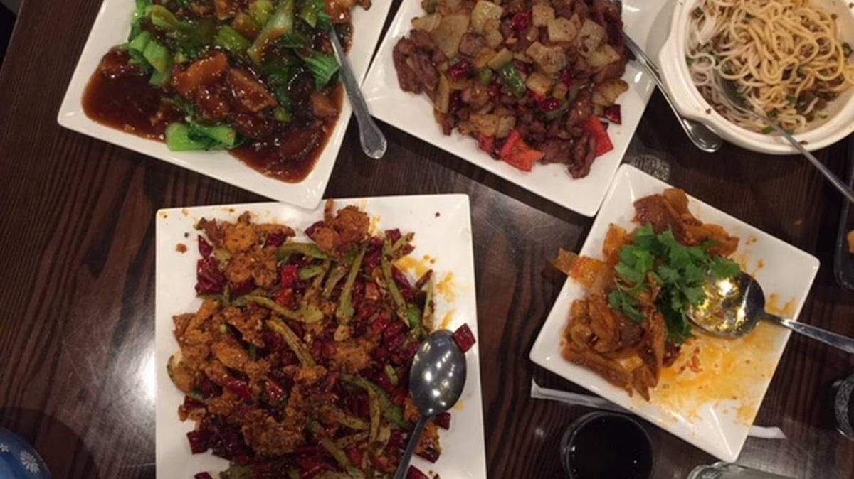 Fans of authentic Chinese food can fill up a table quickly with dishes such as (clockwise from upper left) bok choy with glazed mushrooms, softshell crabs with red chiles and celery, Dan Dan noodles, Happy Couple (cold beef tendon and tripe in hot chile oil) and cumin lamb. Photo by Kathleen Purvis