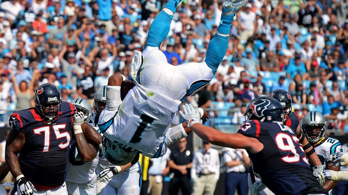 Carolina Panthers quarterback Cam Newton flips through the air over the goal line for a touchdown during third quarter action vs the Houston Texans at Bank of America Stadium in Charlotte, NC on Sunday, September 20, 2015. The Panthers defeated the Texans 24-17.
