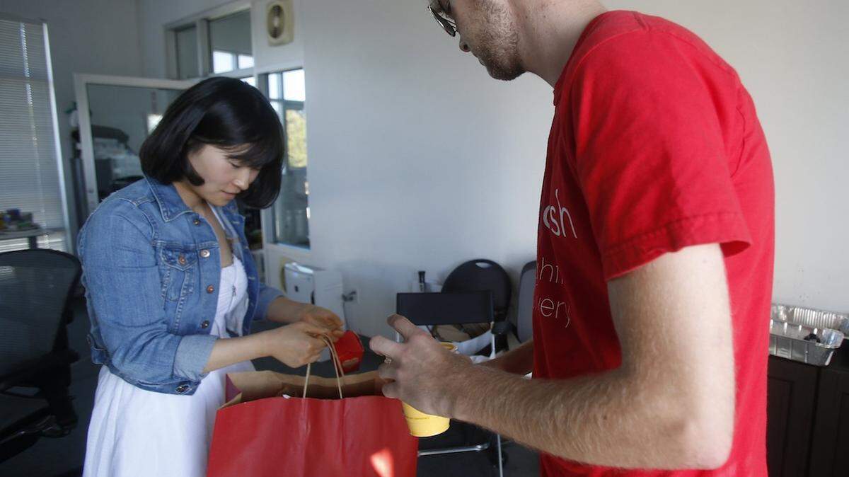 DoorDash driver Jake Vertin, right, drops off a Curry Up Now order to Chong Zhang, August 21, 2013, in Palo Alto, California. (Nhat V. Meyer/Bay Area News Group)