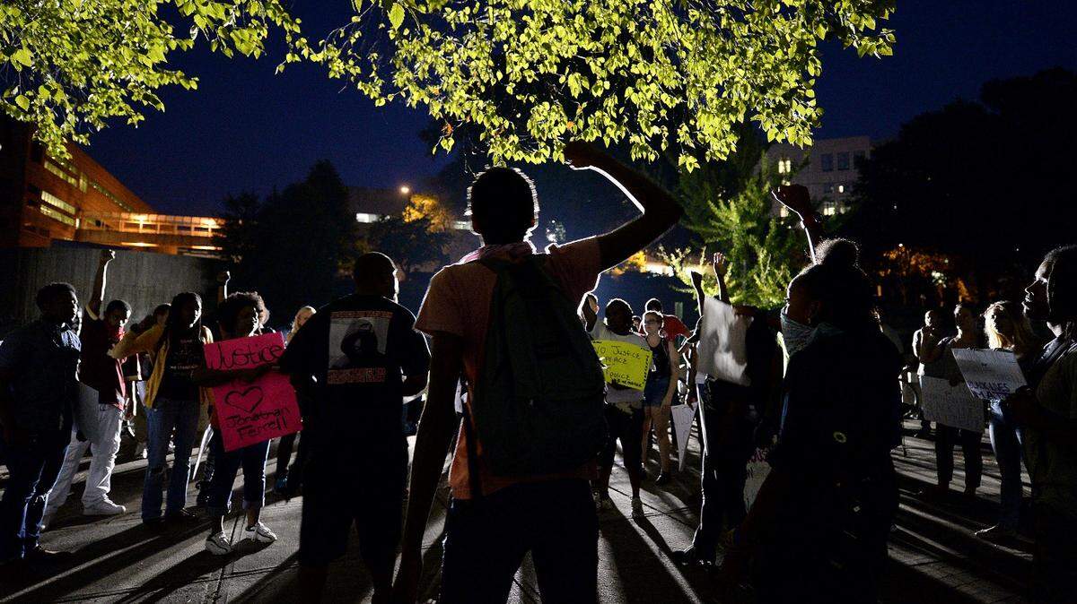 Protesters stand at Marshall Park in Charlotte, NC giving individual remarks on Saturday, August 22, 2015. Protesters marched on Friday evening and Saturday protesting that after four days of deliberations, a mistrial was declared when the jury was unable to resolve a deadlock in the case of Randall "Wes" Kerrick. Kerrick, a Charlotte-Mecklenburg Police officer accused of killing an unarmed man, Jonathan Ferrell, in a struggle two years ago.