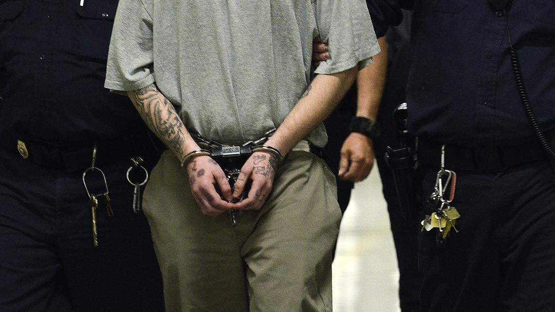 A handcuffed inmate is escorted down the hallway of a North Carolina prison. The state’s prison grievance system is riddled with problems, including conflicts of interest and officers that toss away complaints without investigating them, a new report says.