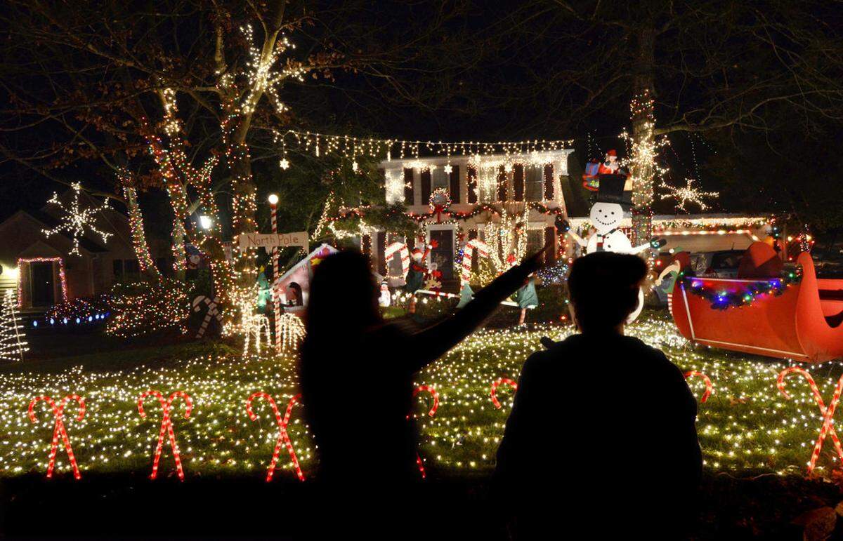 Neighbors enjoy the thousands of Christmas lights on display at Jim Miller's home at 7323 Sherwood Forest Dr. in south Charlotte Friday night Dec. 7, 2012. DIEDRA LAIRD - dlaird@charlotteobserver.com
