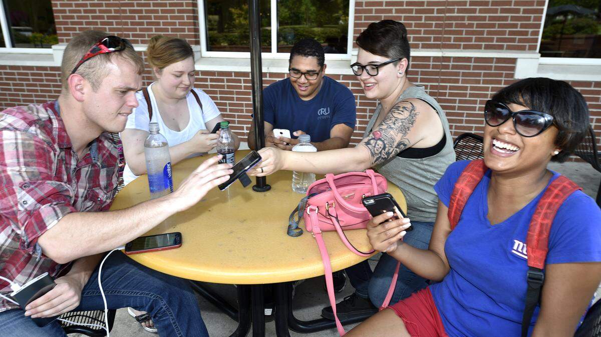 From left, Jeffrey Edwards, Ashley Holmes, Nestor Bonilla, Jessica Sharp and Keyanna Arnett use their cell phones to play Pokémon Go at Augusta University in Augusta, Ga., Tuesday, July 12, 2016.  (Michael Holahan/The Augusta Chronicle via AP)