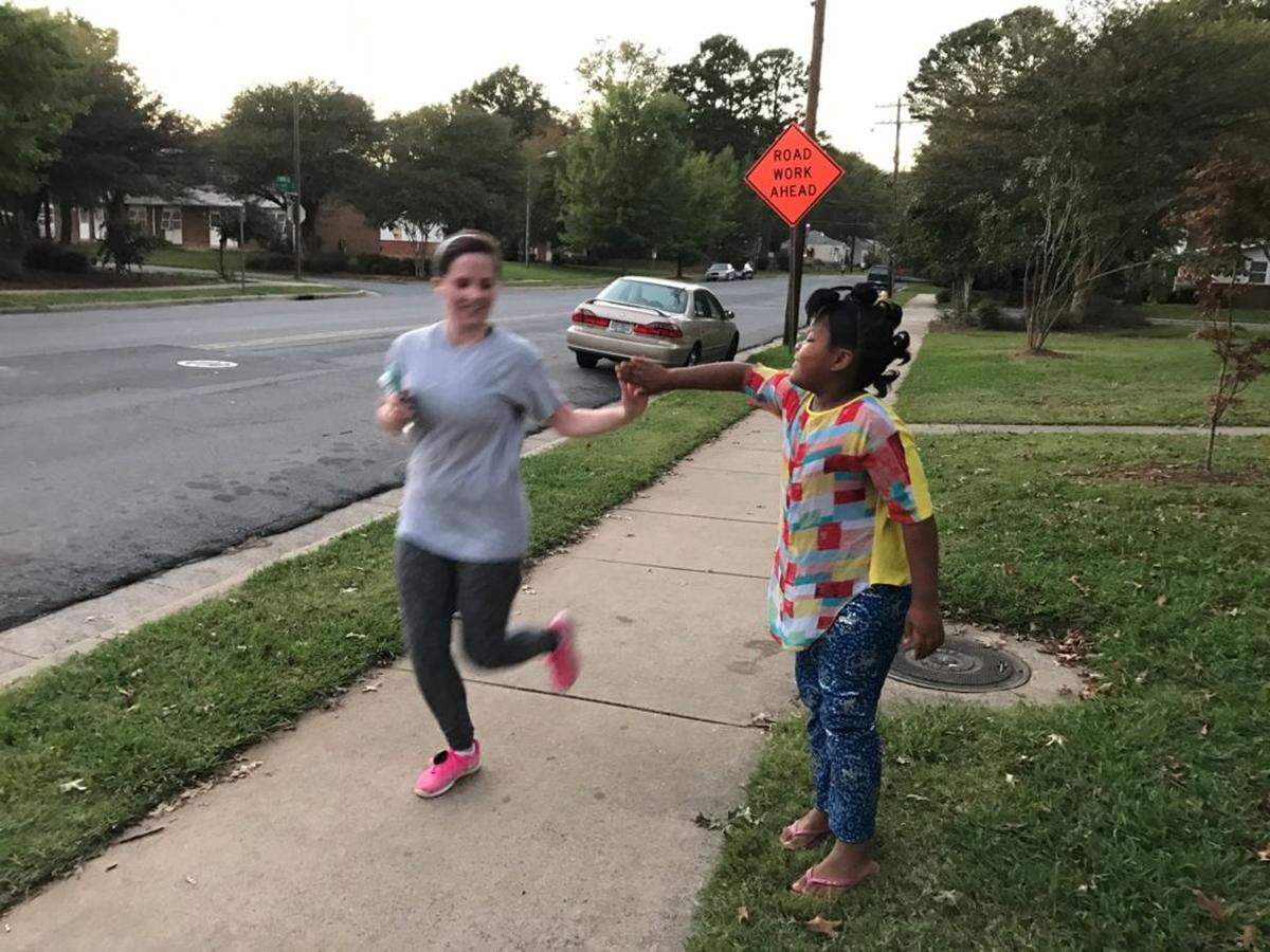 Makaylah Gray, 8, high fives a runner as she goes by.