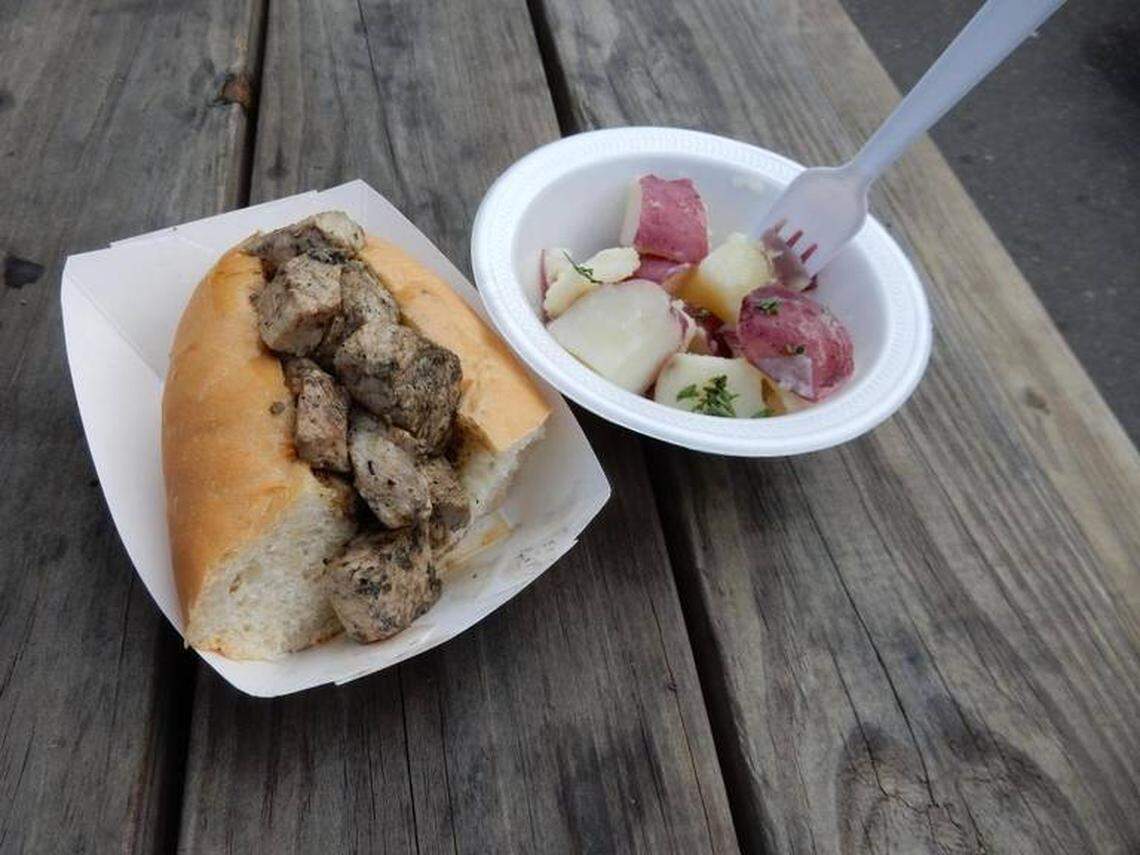 Herb-flecked cubes of pork nestle into an Italian hoagie roll. Salt potatoes on the side.