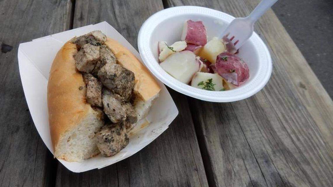 Herb-flecked cubes of pork nestle into an Italian hoagie roll. Salt potatoes on the side.