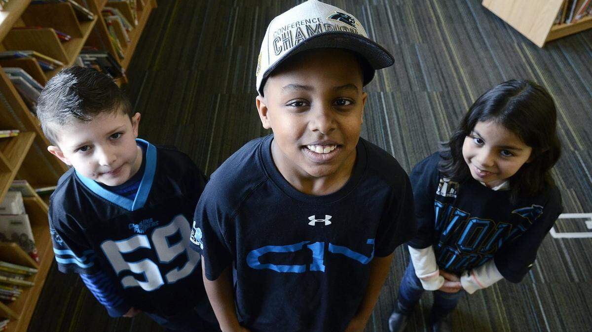 (L-R) Second grader, Dane Howard, 7, fifth grader, Mac McManus, 10 and first grader, Jasmine Olivia-Villatoro, 7, are proud Panthers fans at newell elementary.
 Kids love the Panthers as much as adults do, maybe even more. Students at  Newell elementary School in Charlotte talk about being fans on Wednesday, Jan. 27, 2016.