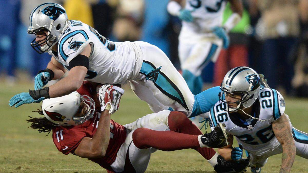 Cardinals wide receiver Larry Fitzgerald is taken down by Panthers defenders Luke Kuechly and Cortland Finnegan in the third quarter at Bank of America Stadium in Charlotte, NC on Sunday, January 24, 2016. The Panthers hosted the Arizona Cardinals in the NFC Championship game.