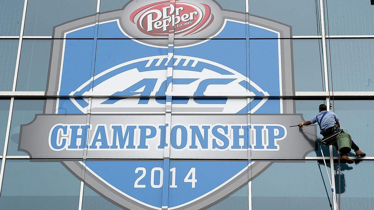 A window washer cleans the ACC Championship logo on the side of Bank of America Stadium in preparation for tomorrow's ACC Championship game. For story about the business impact of the ACC football championship game being played at Bank of America stadium Saturday night.