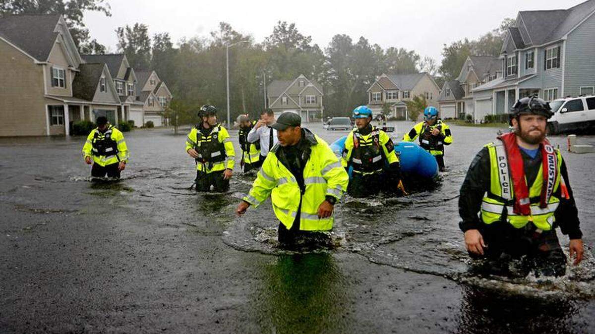 Members of the North Carolina Task Force urban search and rescue team wade through a flooded neighborhood looking for residents who stayed behind as Florence continues to dump heavy rain in Fayetteville, N.C., Sunday, Sept. 16, 2018. Photo by David Goldman/AP.