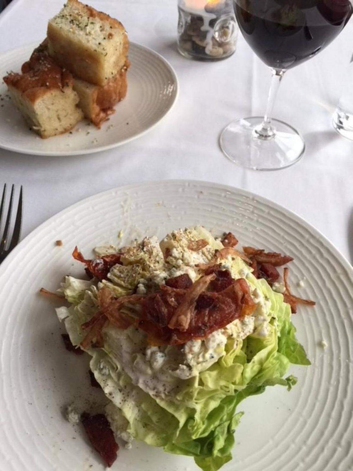 The Wedge Salad at Porter’s House is topped with a slow-roasted confit tomato. On the side: Butter-drenched soft focaccia.Photo by Kathleen Purvis