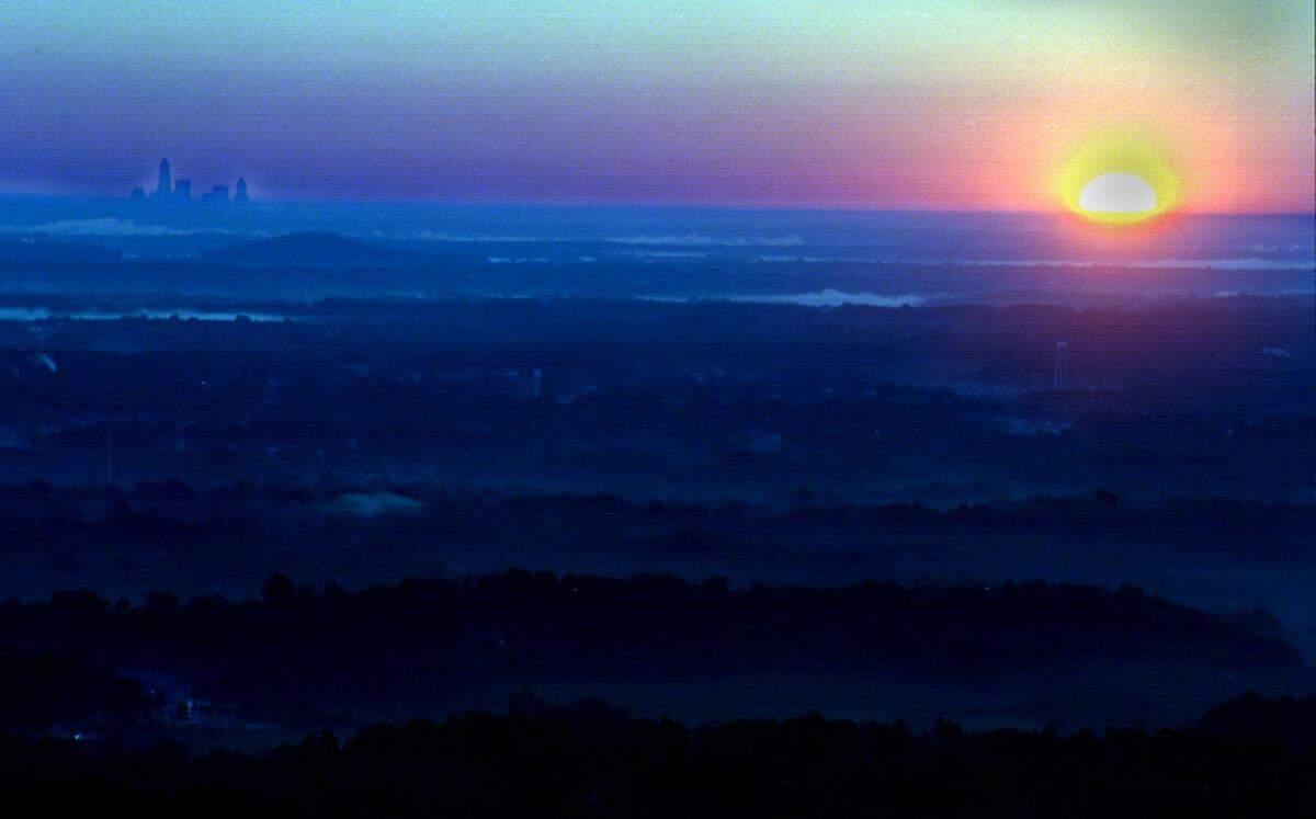 10/13/96 1L ROBERT LAHSER/Staff  The sun rises over the flatness of eastern Gaston County, as seen from the top of Crowders Mountain. A county whose residents traditionally share many characteristics is growing increasingly as diverse as its topography.   (UNPUBLISHED NOTES:)   (10/10/96ROBERTS) For Townships package. Sunrise from atop Crowder's Mountain eastern Gaston County. ROBERT LAHSER/STAFF