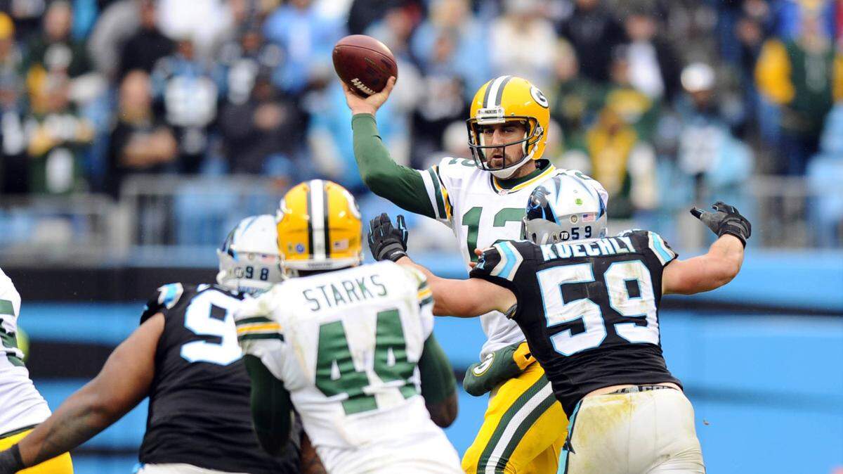 Green Bay Packers' Aaron Rodgers (12) passes against the pressure from Carolina Panthers' Luke Kuechly (59) in the fourth quarter at Bank of America Stadium on Sunday, November 8, 2015. The Panthers won 37-29, and improve to 8-0.