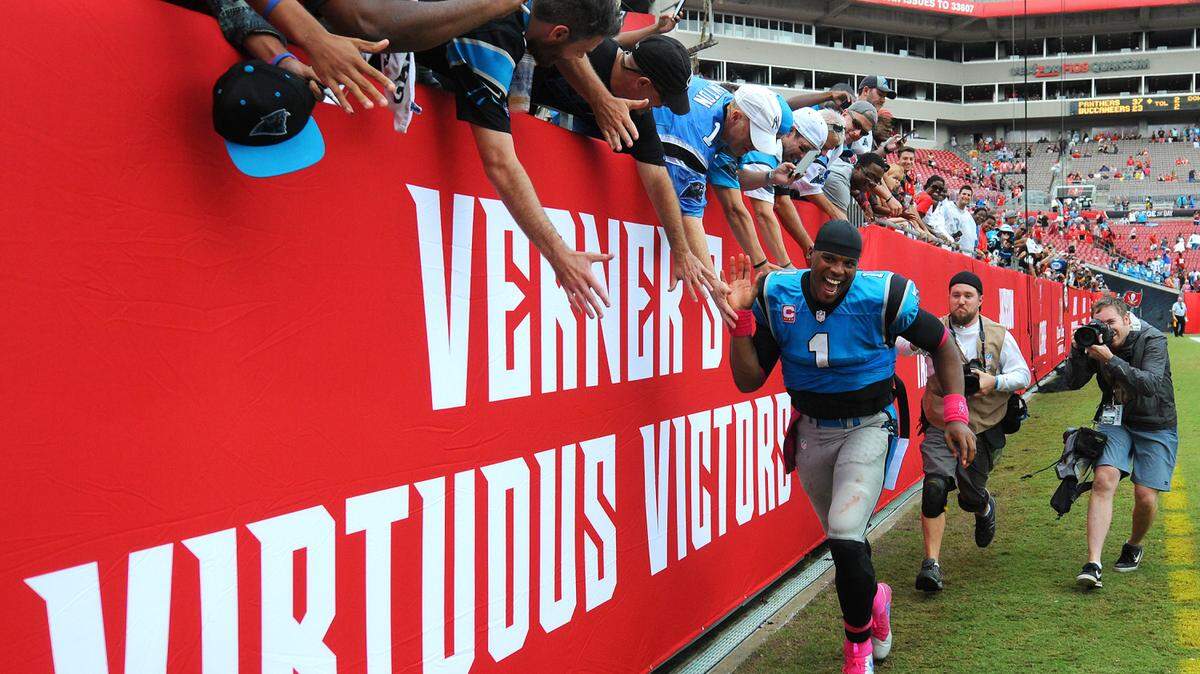 Carolina Panthers quarterback Cam Newton, right, slaps hands with fans as they celebrate the team's 37-23 victory over the Tampa Bay Buccaneers on Sunday, October 4, 2015 at Raymond James Stadium in Tampa, Fl.