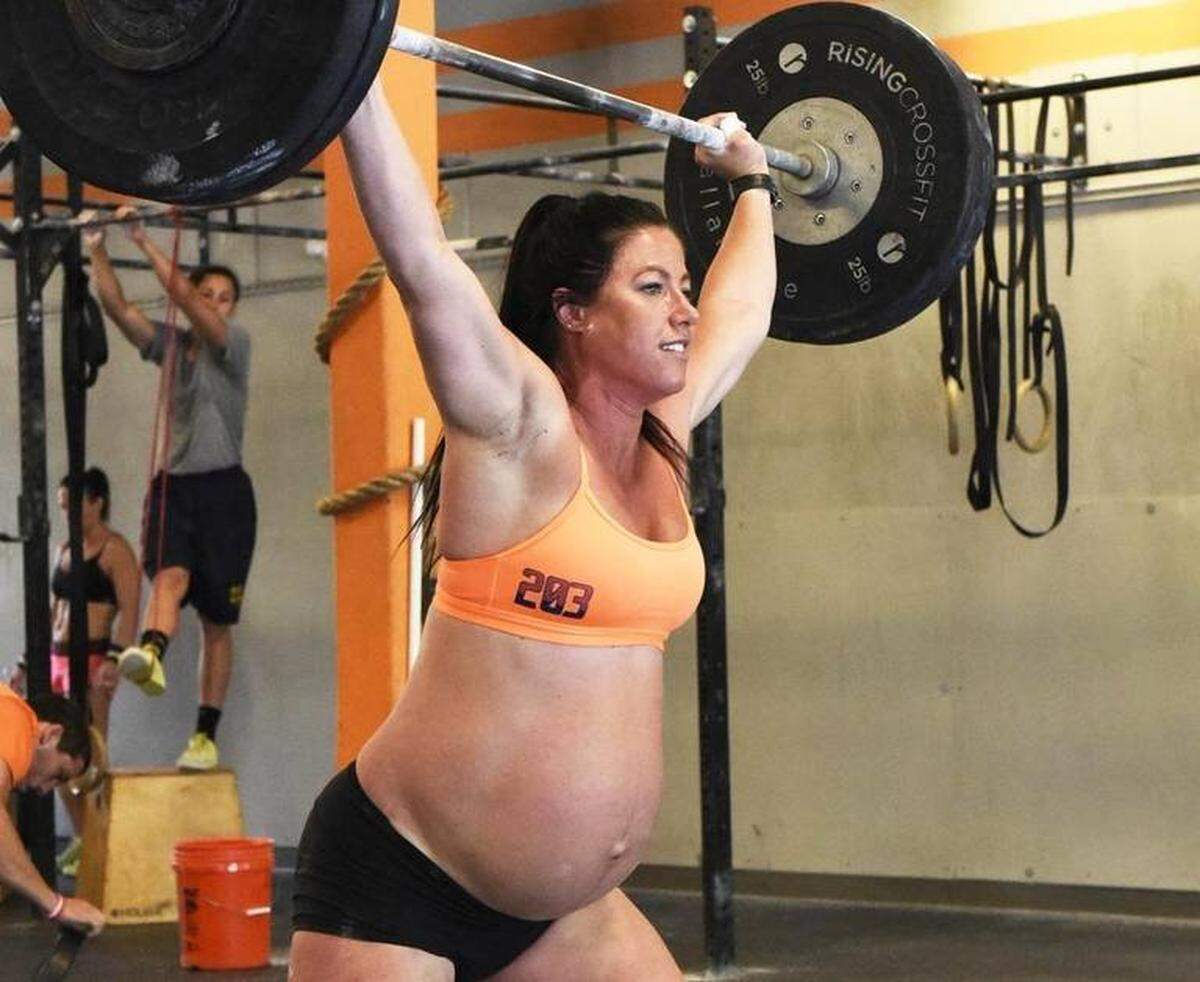 Emily Breeze Watson of Charlotte lifts weights during her workout at Rising Crossfit Ballantyne on May 10, 2016. Despite being overdue to deliver her first child, the 31-year-old fitness instructor and CrossFitter is still working out two hours a day, six days a week. Photo: Robert Lahser rlahser@charlotteobserver.com