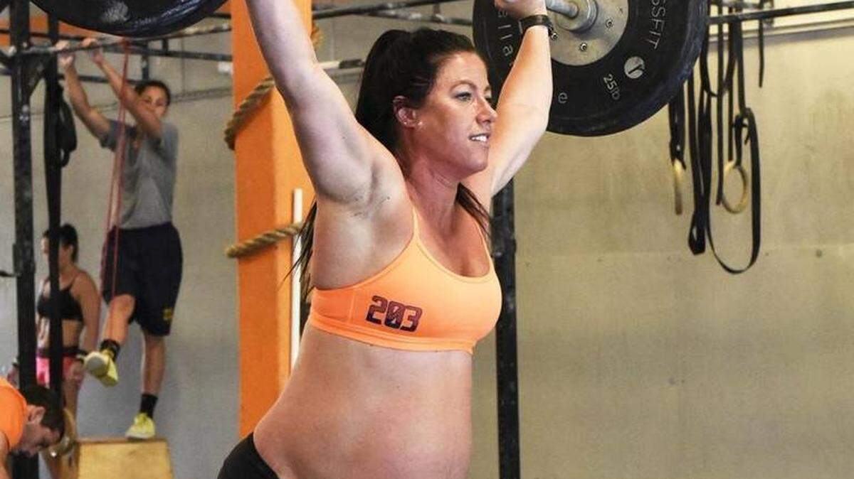 Emily Breeze Watson of Charlotte lifts weights during her workout at Rising Crossfit Ballantyne on May 10, 2016. Despite being overdue to deliver her first child, the 31-year-old fitness instructor and CrossFitter is still working out two hours a day, six days a week. Photo: Robert Lahser rlahser@charlotteobserver.com