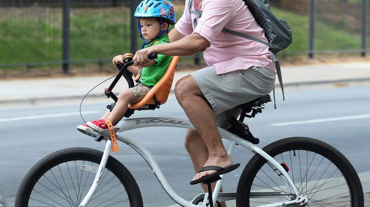 Gus Obleada and his son Cooper, 21/2, enjoy a bike ride up N. Trade St. near the Square uptown in Sunday's beautiful weather.