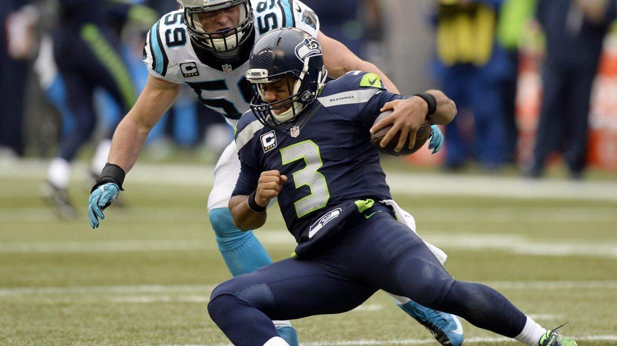Seattle Seahawks' Russell Wilson (3) slides as Carolina Panthers' Luke Kuechly (59) closes in during the third quarter at CenturyLink Field on Sunday, October 18, 2015. The Panthers won, 27-23.