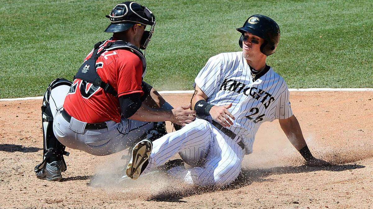 Charlotte Knights runner Tyler Colvin on right, slides in safe to home plate to score a home run, Indianapolis Indians catcher Tony Sanchez makes the tag too late during Sunday's game played at BB&amp;T BallPark June 21,2015. The Charlotte Knights won 13-1.