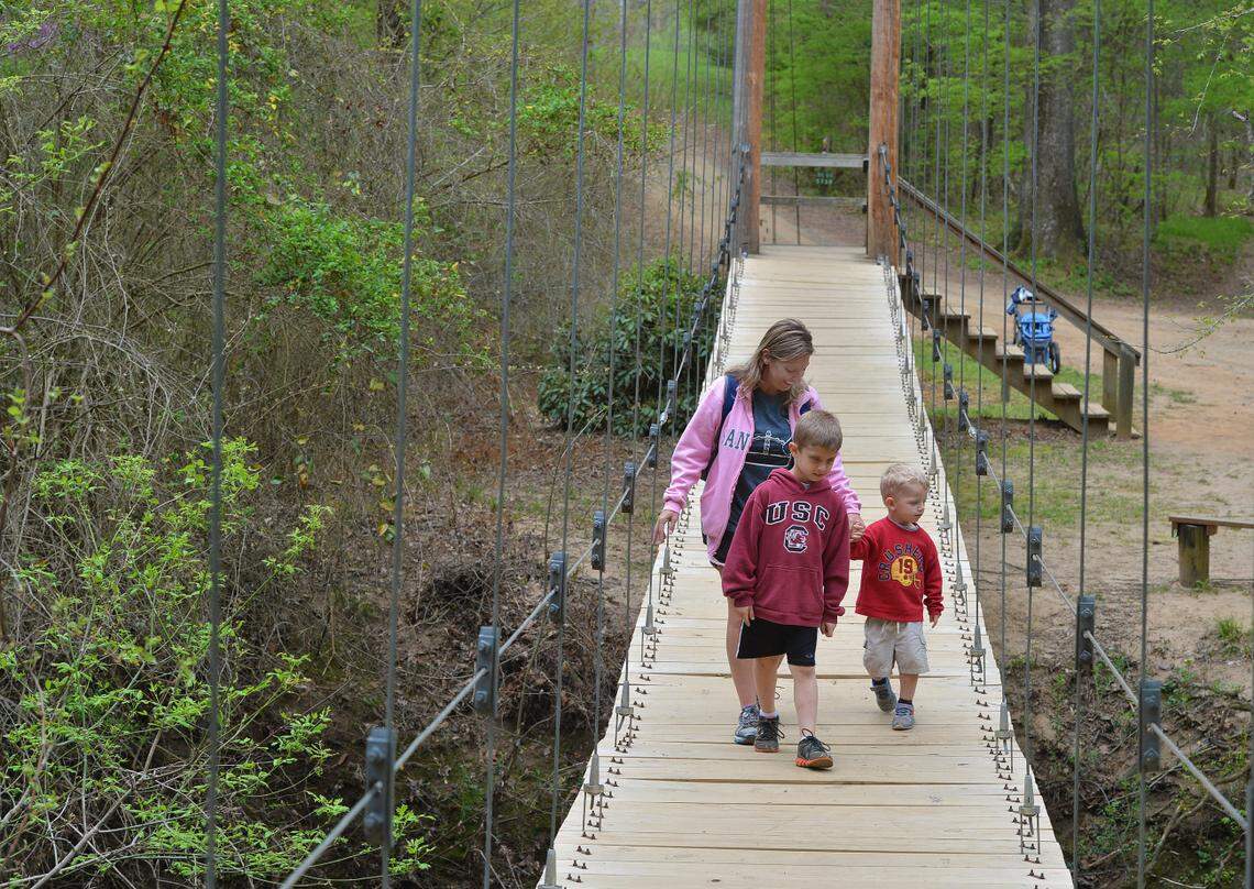 A walk over swing bridge is how people cross over Steel Creek. Effort underway to raise money to keep Anne Close Springs Greenway going for decades to come as community green space.