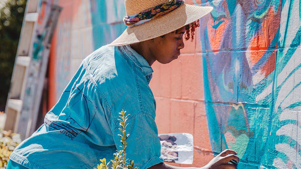 Georgie Nakima (Garden of Journey) paints at Salon 1226 during the Talking Walls festival